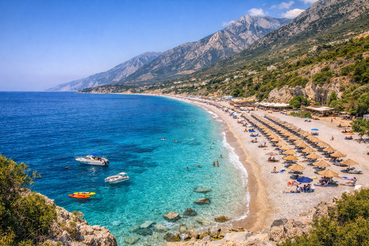 Dhermi Beach on the Albanian Riviera with turquoise waters, white pebble shore, and mountain backdrop.