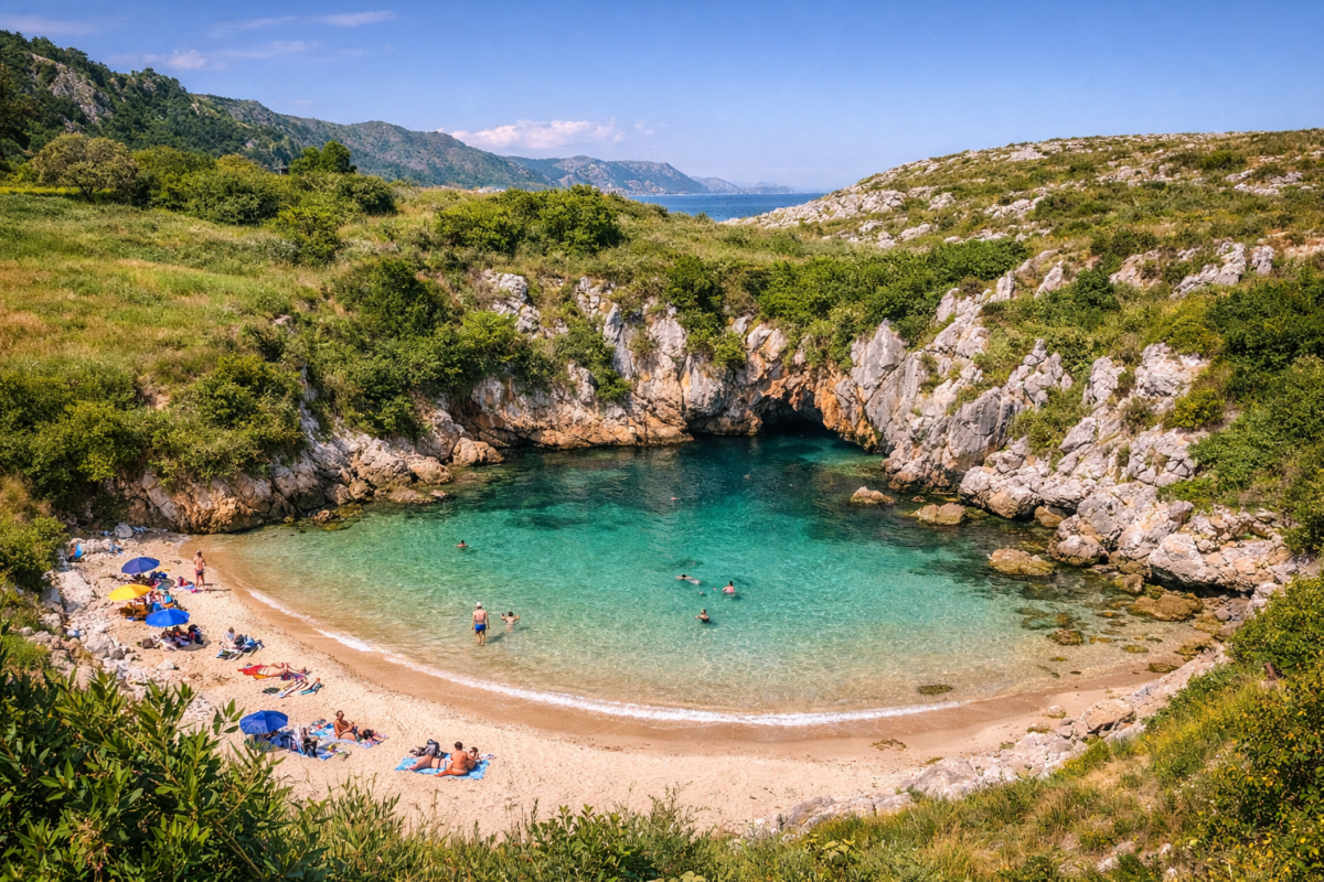 Playa de Gulpiyuri in Asturias with hidden cove, sandy beach, and lush green cliffs.